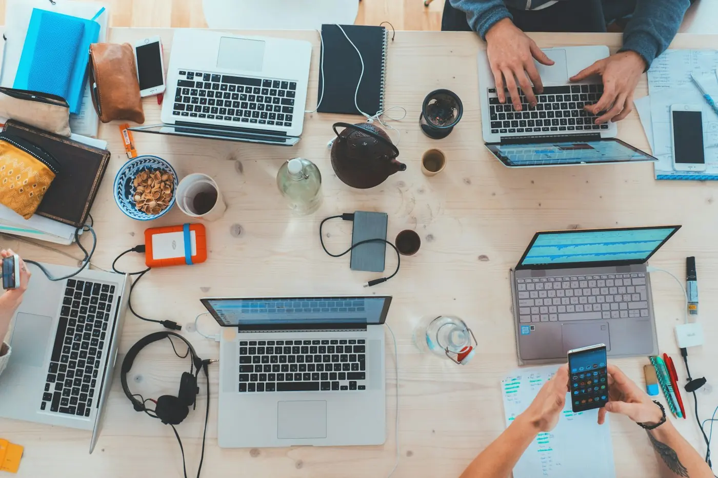 Team workspace with laptops, notebooks and mobile devices
